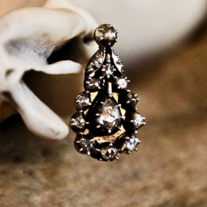 A close up image of one of a pair of Georgian Diamond Earrings. The earring is tear drop in shape with 16 rose-cut diamonds.