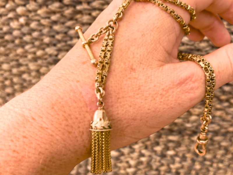 a-pin-of-gold-9ct-rose-gold-albertina-chain-2 An image of an antique 9ct yellow gold Albertina chain wound around a woman's hand.