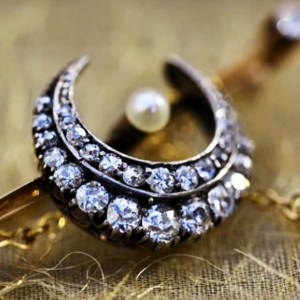 An image of a vintage half-moon brooch.